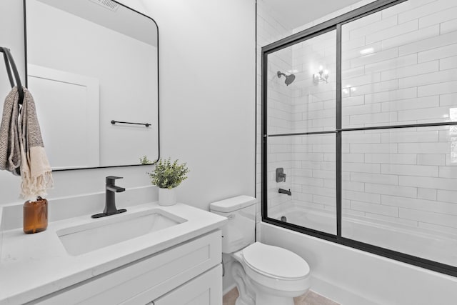 full bath featuring combined bath / shower with glass door, vanity, and toilet