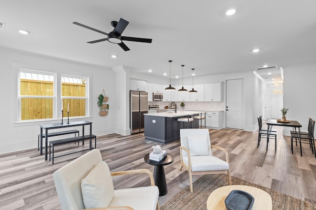 living area featuring light wood-style floors, visible vents, a ceiling fan, and recessed lighting