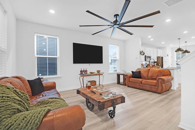 living room featuring ceiling fan and light hardwood / wood-style floors