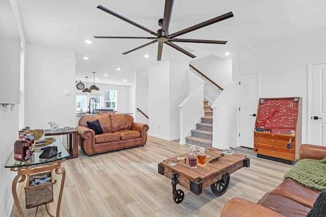 living room featuring ceiling fan, sink, and light hardwood / wood-style flooring