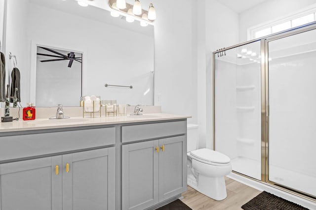 bathroom featuring hardwood / wood-style floors, vanity, toilet, and a shower with shower door