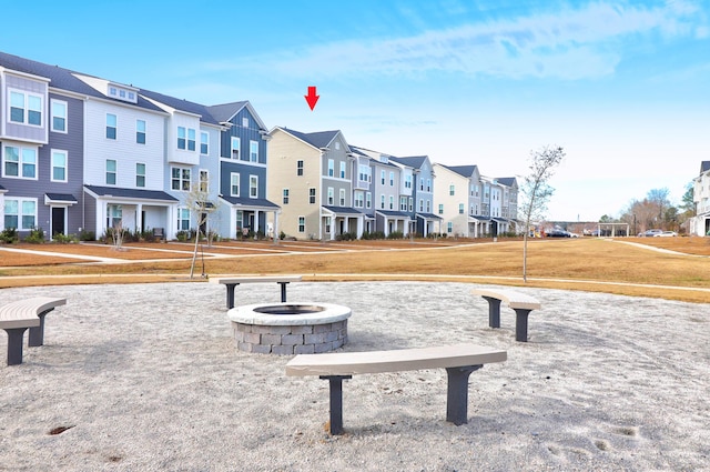 view of property's community with a lawn and a fire pit