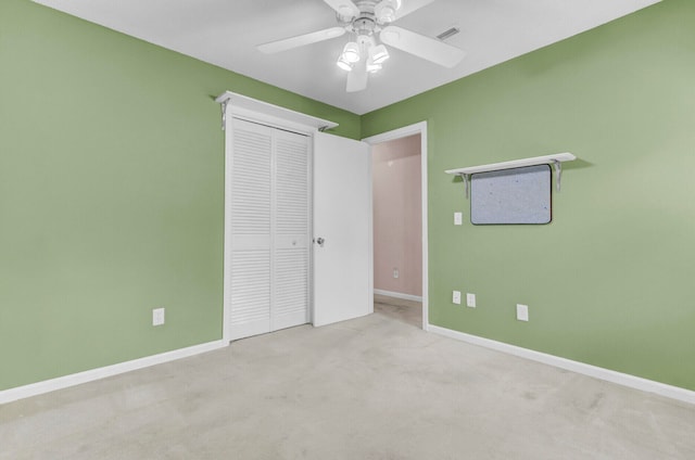 unfurnished bedroom featuring light colored carpet, ceiling fan, and a closet