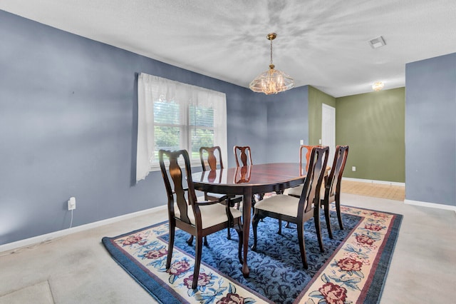 dining area with a textured ceiling and an inviting chandelier