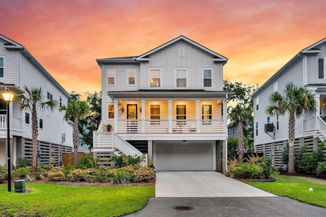 1494 N Lakeshore Dr, Mount Pleasant, SC 29466 - coastal inspired home with board and batten siding, stairway, a porch, a garage, and a front lawn