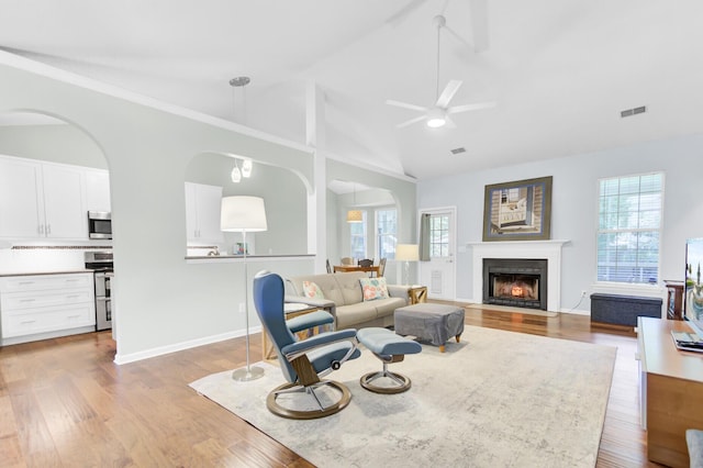 5406 Dwight Dr, North Charleston, SC 29420 - living room with ceiling fan, wood finished floors, a fireplace with flush hearth, arched walkways, and high vaulted ceiling