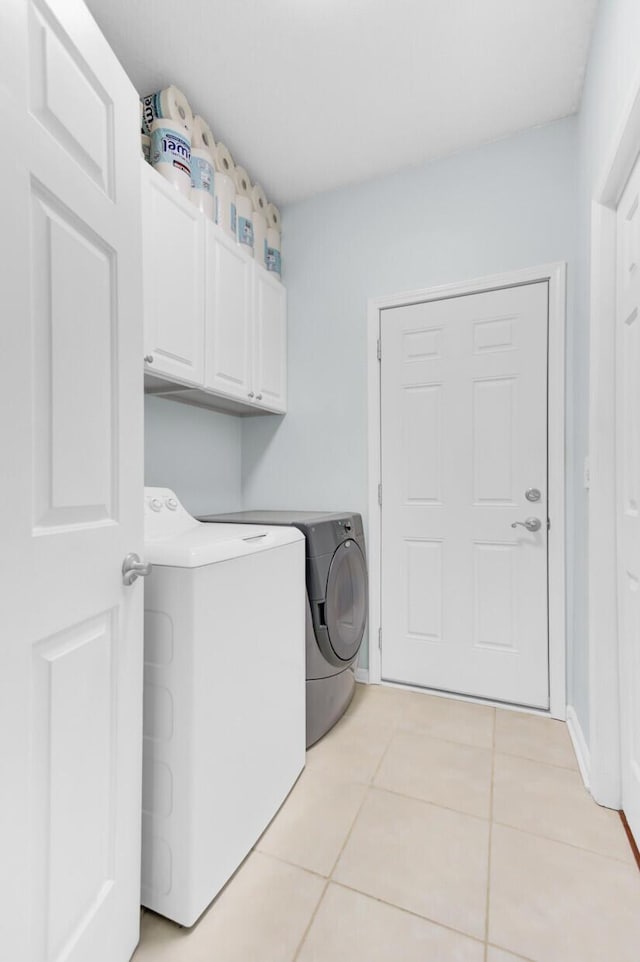 5406 Dwight Dr, North Charleston, SC 29420 - laundry area featuring cabinet space, washing machine and clothes dryer, and light tile patterned floors