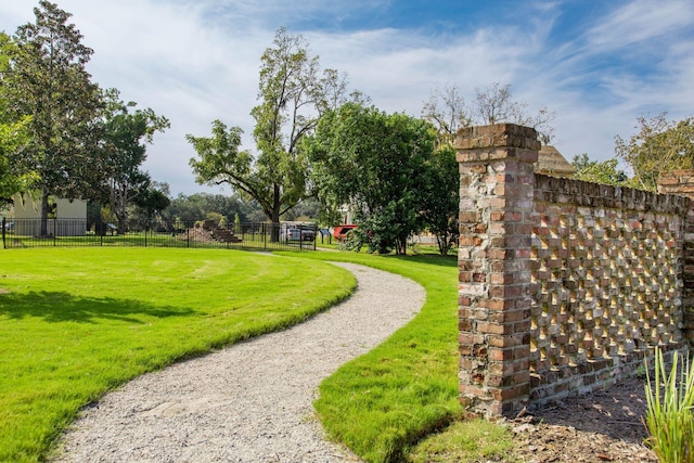 view of property's community with a yard and fence