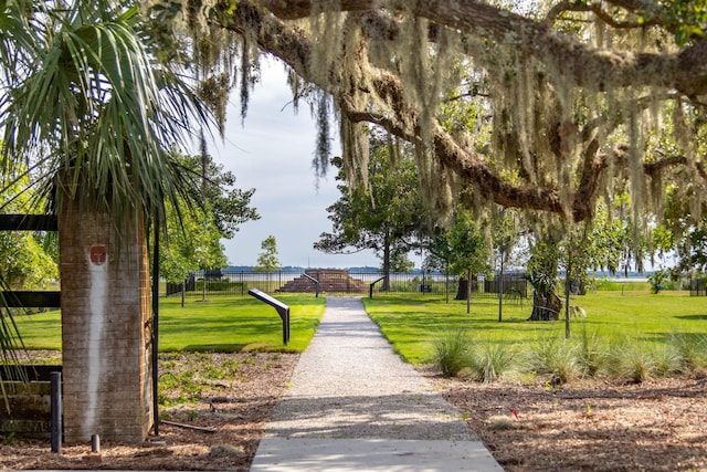 view of community featuring fence and a yard