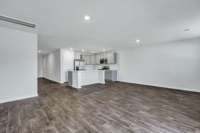 unfurnished living room with dark wood finished floors, visible vents, recessed lighting, and baseboards