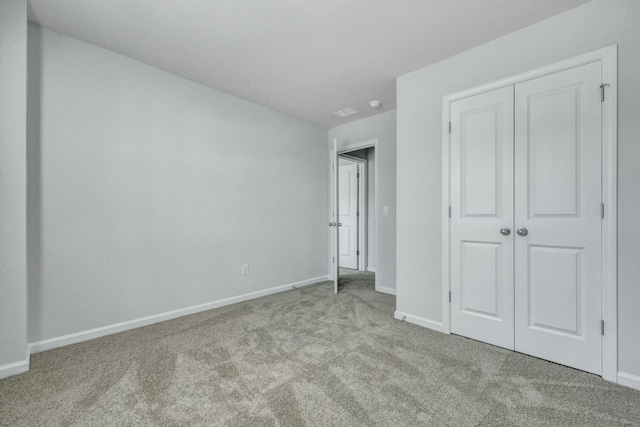 unfurnished bedroom with a closet, carpet flooring, and baseboards