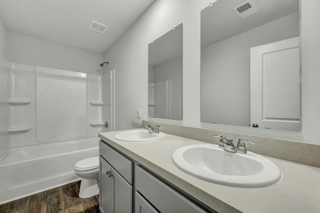 full bathroom with toilet, wood finished floors, visible vents, and a sink