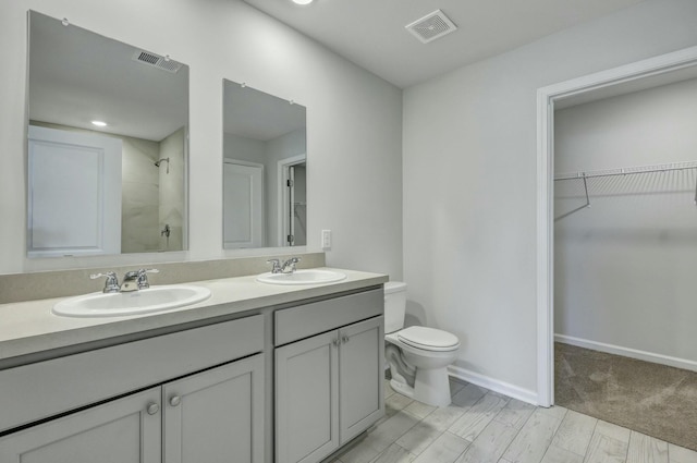 full bathroom featuring toilet, walk in shower, visible vents, and a sink