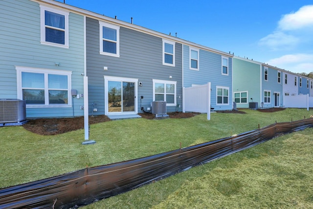 back of house featuring central air condition unit, a yard, and fence