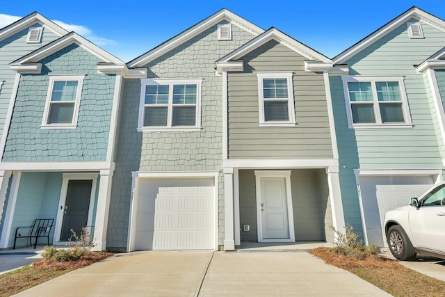 multi unit property featuring concrete driveway and a garage