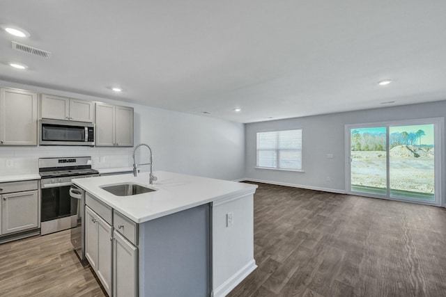 kitchen with tasteful backsplash, visible vents, gray cabinetry, appliances with stainless steel finishes, and a sink