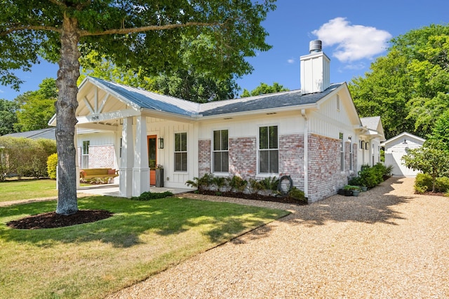 1474 Indian St, Mount Pleasant, SC 29464 - single story home featuring a front lawn, board and batten siding, a chimney, brick siding, and an outbuilding