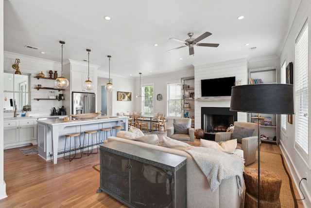 1474 Indian St, Mount Pleasant, SC 29464 - living area featuring recessed lighting, ceiling fan, light wood-style flooring, a fireplace, and crown molding
