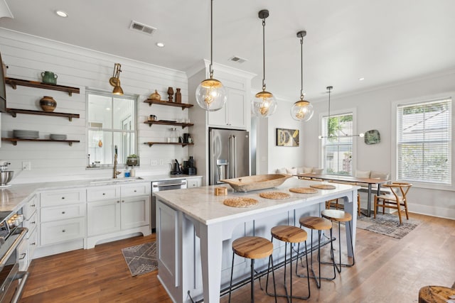 1474 Indian St, Mount Pleasant, SC 29464 - kitchen with open shelves, stainless steel appliances, a sink, dark wood-style floors, and a breakfast bar
