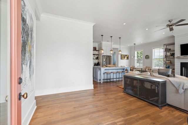 1474 Indian St, Mount Pleasant, SC 29464 - living room with ornamental molding, light wood-style floors, ceiling fan, a fireplace, and recessed lighting