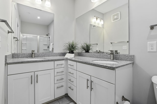 bathroom featuring a shower with shower door, tile patterned floors, vanity, and toilet