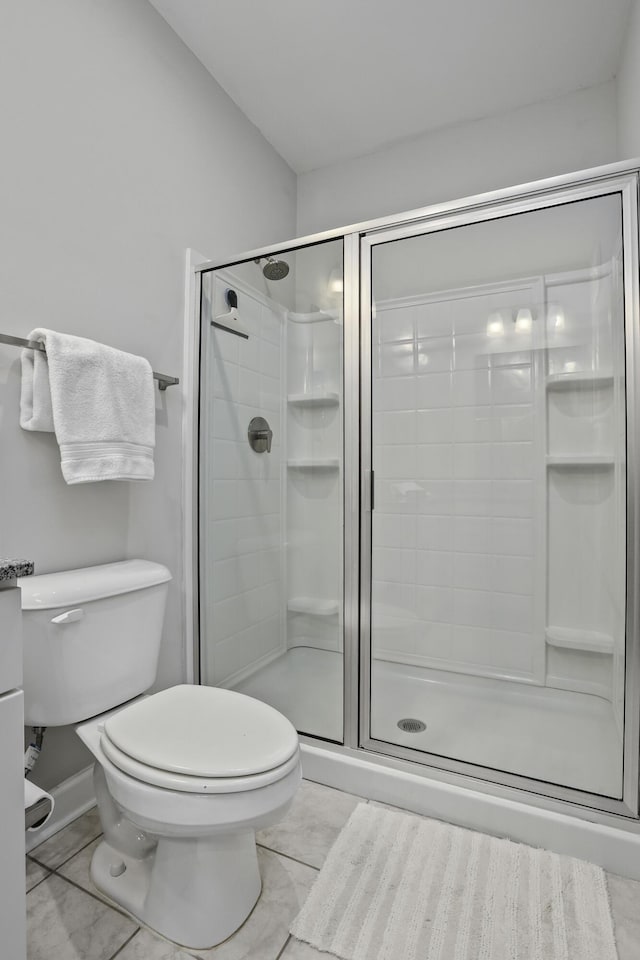 bathroom with toilet, an enclosed shower, and tile patterned flooring