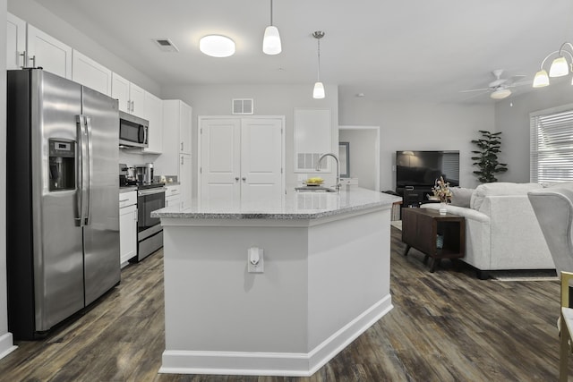 kitchen with pendant lighting, appliances with stainless steel finishes, white cabinetry, sink, and a kitchen island with sink