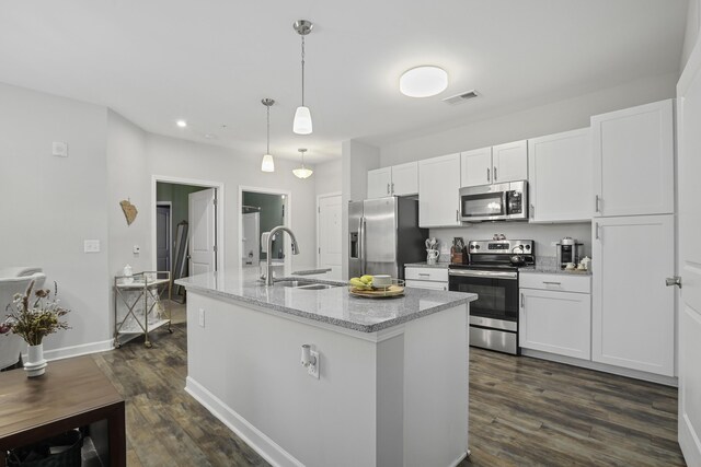 kitchen featuring a center island with sink, stainless steel appliances, pendant lighting, white cabinets, and sink