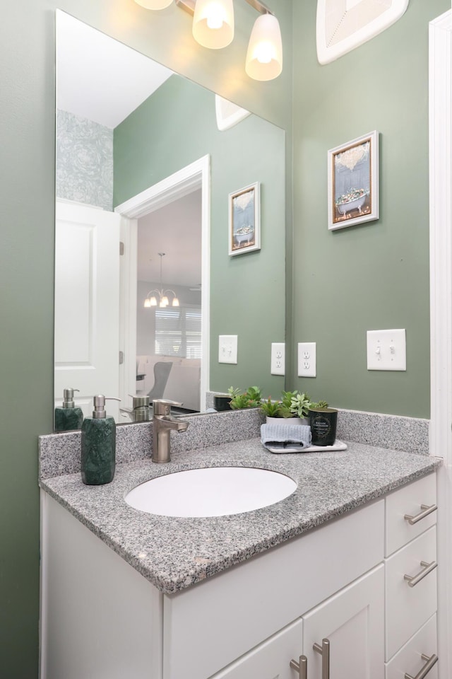 bathroom with vanity and a notable chandelier