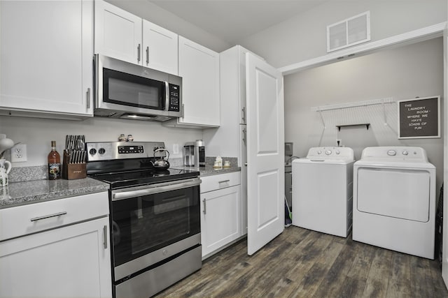 kitchen with white cabinetry, stainless steel appliances, dark hardwood / wood-style floors, dark stone countertops, and washing machine and dryer