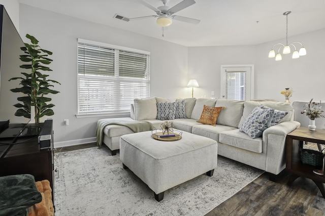 living room featuring ceiling fan with notable chandelier and dark hardwood / wood-style floors