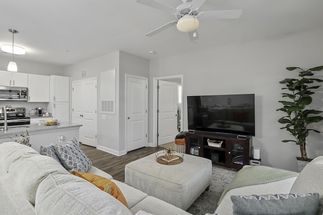 living room featuring ceiling fan, dark hardwood / wood-style flooring, and sink