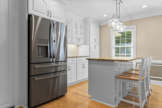 1551 Hutton Pl, Charleston, SC 29407 - kitchen featuring stainless steel refrigerator with ice dispenser, a kitchen bar, white cabinets, light stone countertops, and a center island