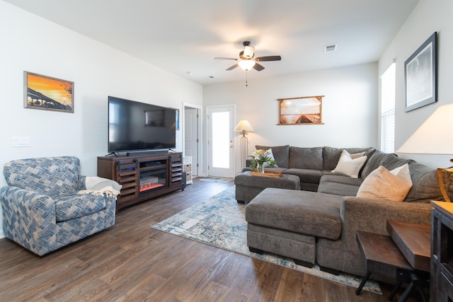 living room featuring ceiling fan and dark hardwood / wood-style floors