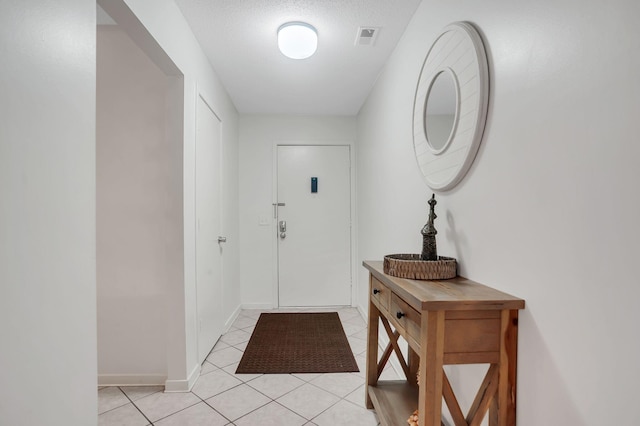 tiled entrance foyer featuring a textured ceiling