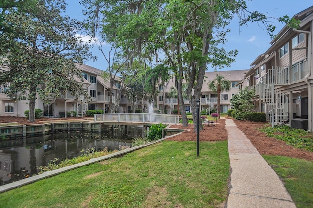 view of home's community featuring a water view and a lawn