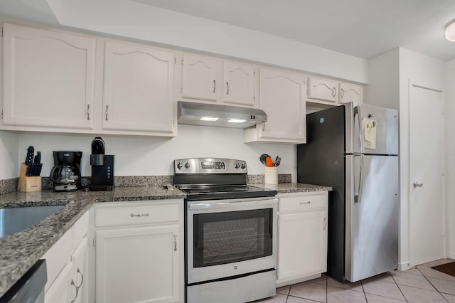 kitchen featuring white cabinetry, light tile patterned floors, stainless steel appliances, and dark stone counters