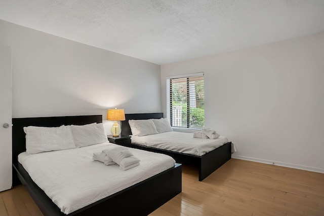 bedroom featuring a textured ceiling and light wood-type flooring