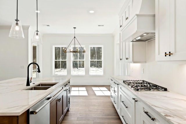 kitchen featuring premium range hood, visible vents, stainless steel appliances, and a sink