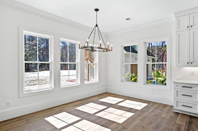 unfurnished dining area featuring dark wood-style floors, a chandelier, visible vents, and baseboards