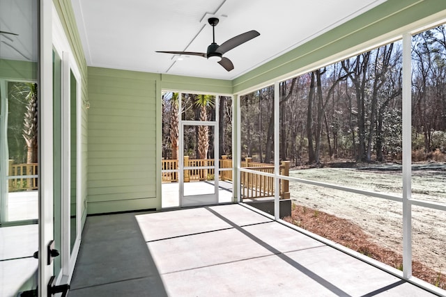 unfurnished sunroom featuring a ceiling fan