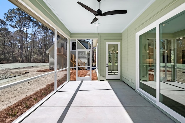 unfurnished sunroom with ceiling fan