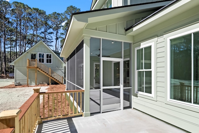 exterior space with a sunroom, stairs, board and batten siding, and a wooden deck