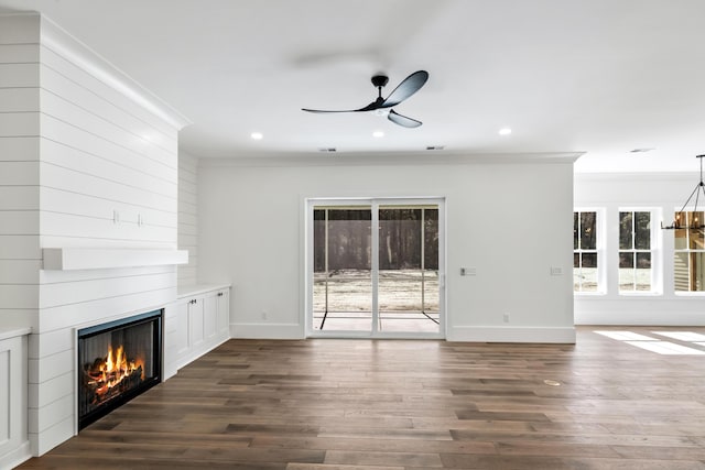 unfurnished living room with a large fireplace, baseboards, dark wood finished floors, and ceiling fan with notable chandelier