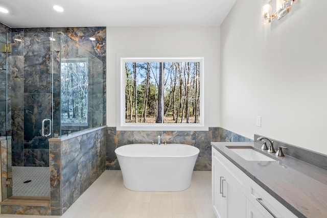 bathroom with a soaking tub, vanity, a shower stall, tile walls, and recessed lighting