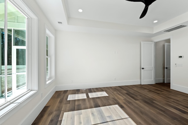 spare room featuring dark wood-style floors, visible vents, and baseboards