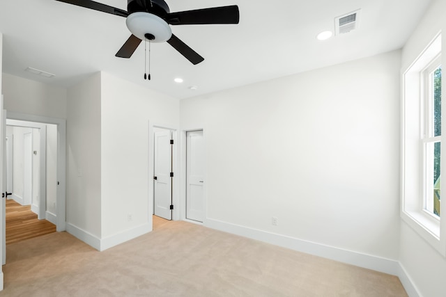 unfurnished bedroom with recessed lighting, light carpet, visible vents, and baseboards