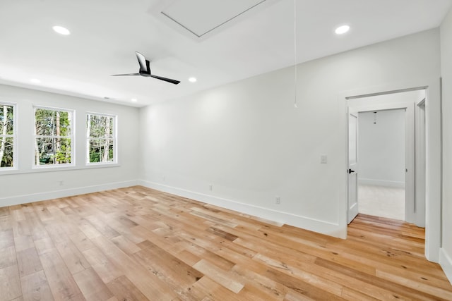 empty room featuring light wood-type flooring, attic access, and recessed lighting