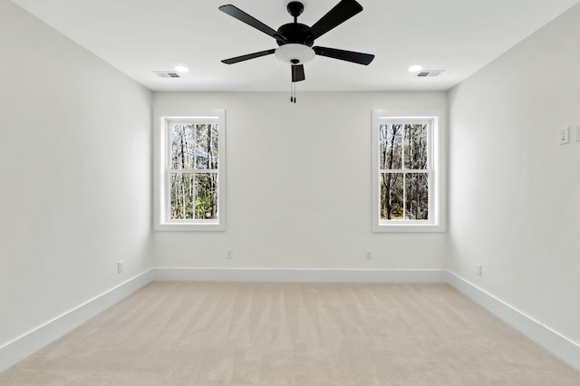 spare room featuring light carpet, visible vents, and baseboards