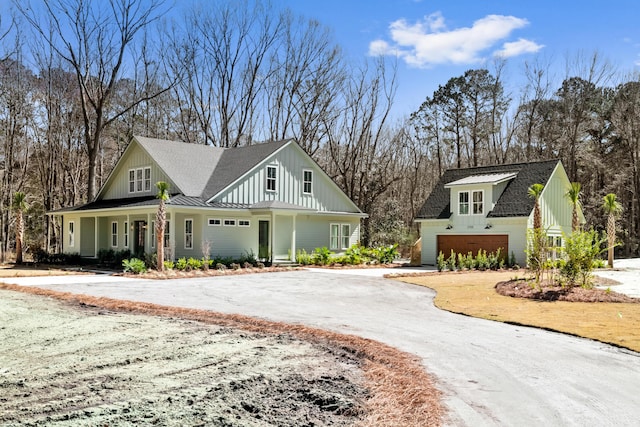 modern inspired farmhouse featuring metal roof, a garage, a shingled roof, board and batten siding, and a standing seam roof